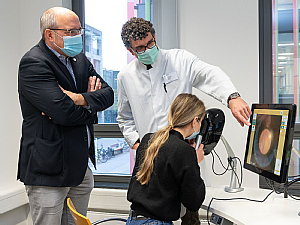 Prof. Dr. Tim U. Krohne (Mitte), Leiter des Netzhaut-Schwerpunkts des Zentrums für Augenheilkunde, und Dr. Christoph Stosch (links), Leiter des KISS, demonstrieren den neuen Funduskopie-Simulator, Foto: Christian Wittke
